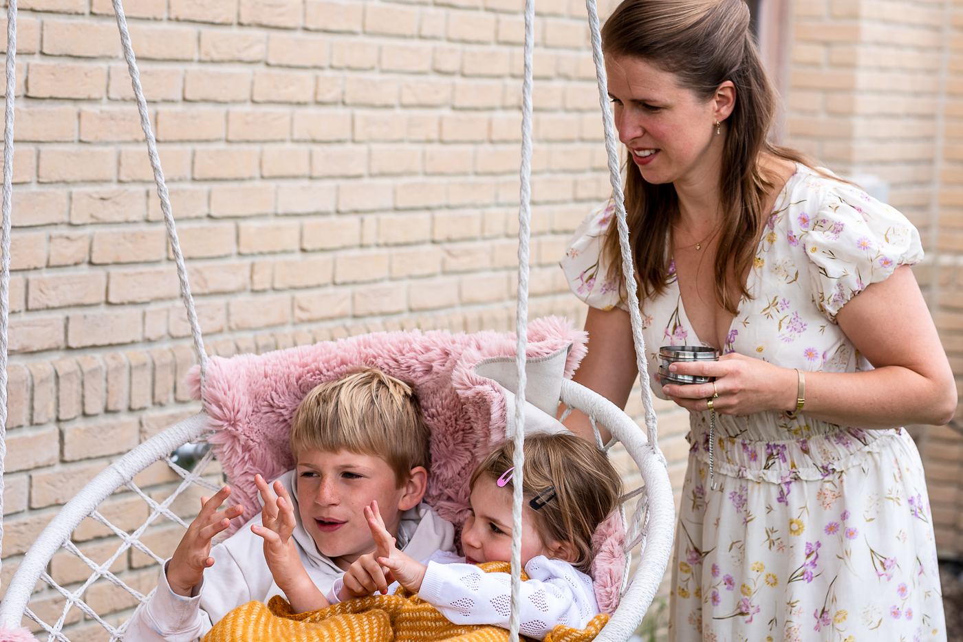 Marien Vermeulen bij de hangschommel met twee van haar kinderen